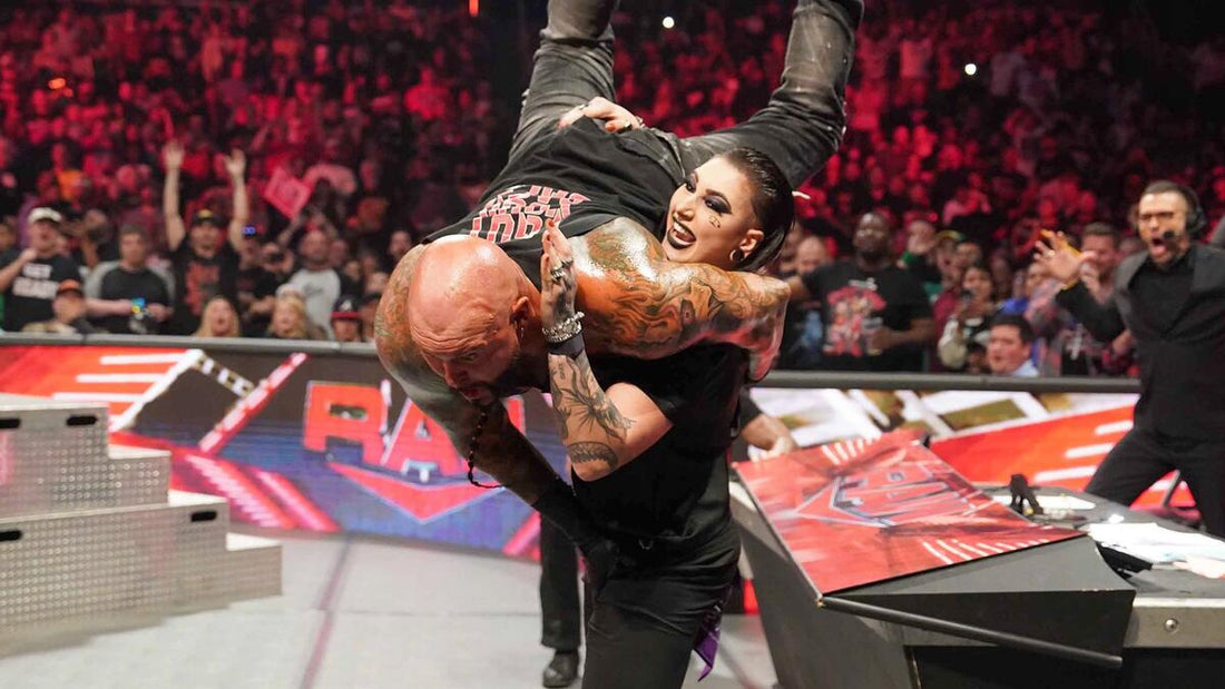 Rhea Ripley lifting a male wrestler upside down during a WWE Raw segment, showing whole-body control in the ring