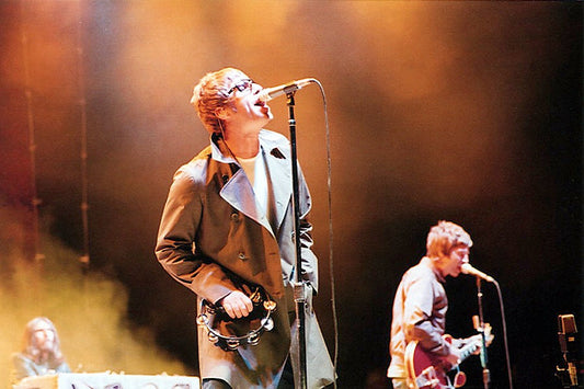 Liam and Noel Gallagher performing live as Oasis with warm stage lights