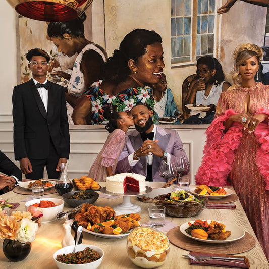 LeBron James seated with his family at a dinner table with cake and food