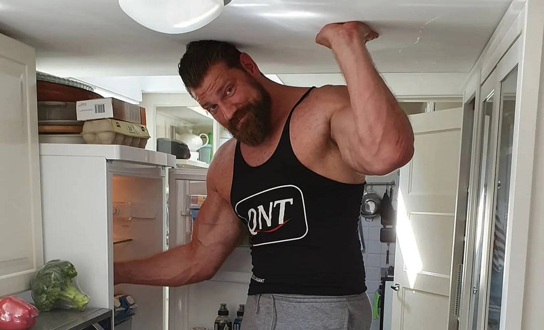 Olivier Richters in a kitchen opening his refrigerator beside eggs and prepared food