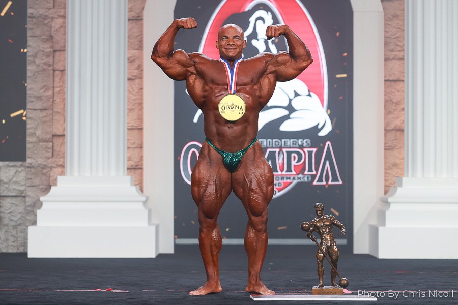 Big Ramy celebrating his 2020 Mr. Olympia victory in a front double biceps pose