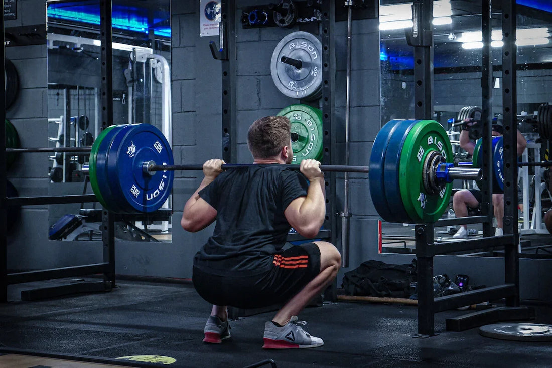 A lifter performing a heavy barbell back squat inside a power rack