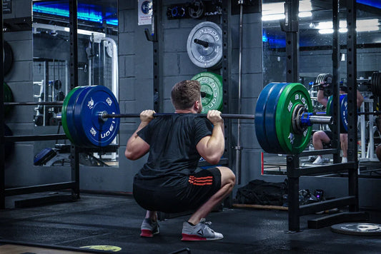 A lifter performing a heavy barbell back squat inside a power rack