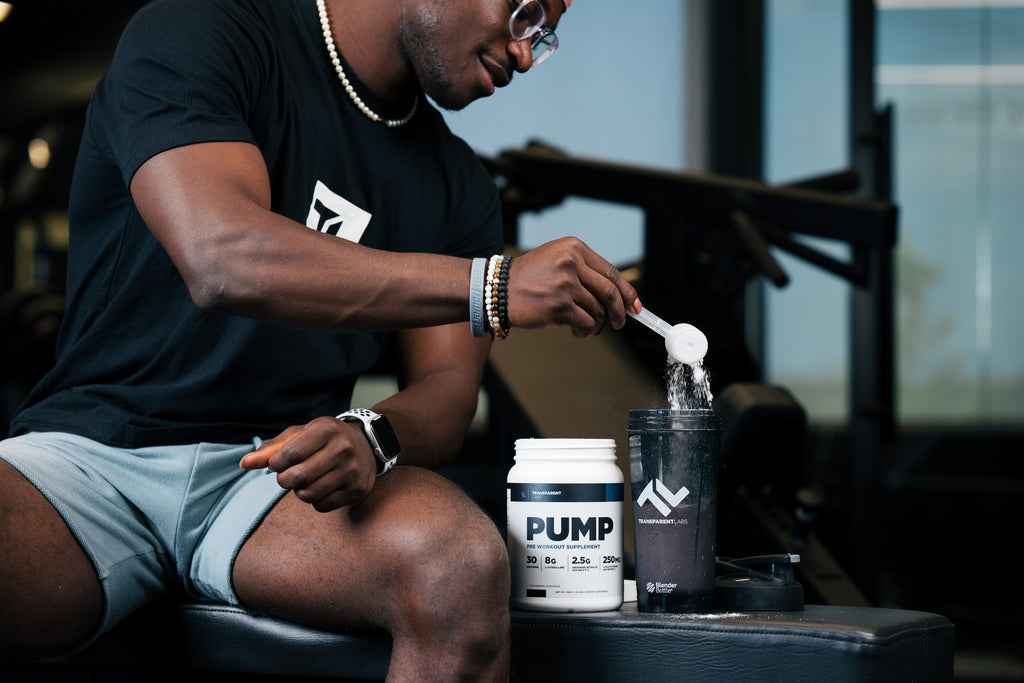 Gym athlete scooping pre-workout powder into a shaker before strength training