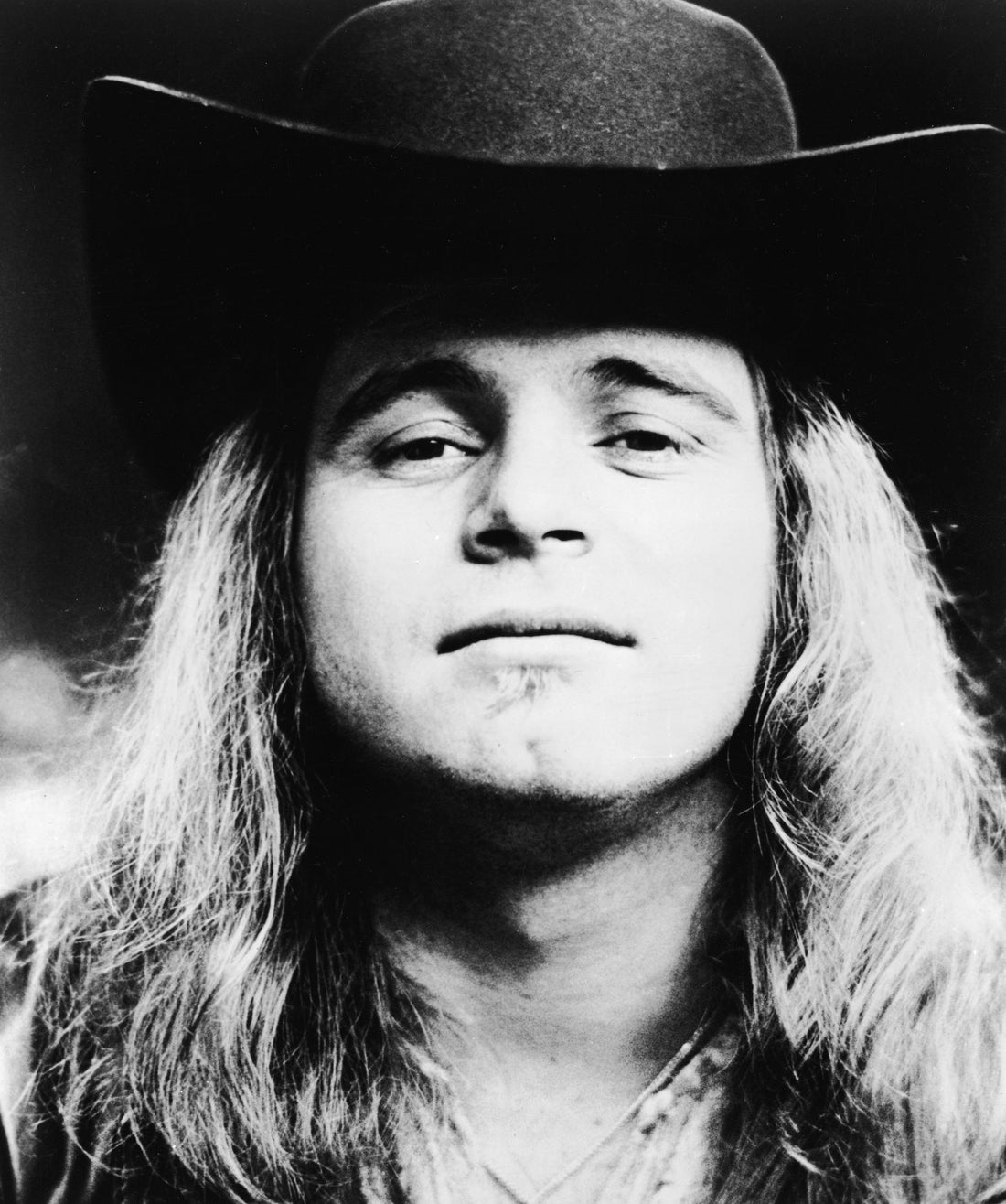 Black-and-white 1976 publicity portrait of Ronnie Van Zant wearing a dark cowboy hat