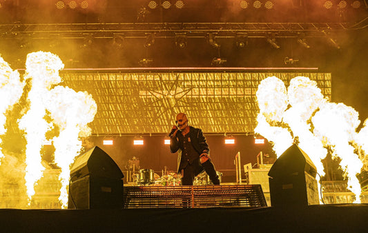 Masked Slipknot vocalist performing at Madison Square Garden with bright flames on both sides of the stage