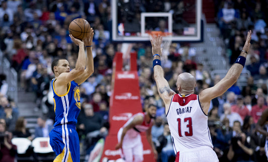 Stephen Curry taking a jump shot for the Golden State Warriors, representing an NBA rumors roundup led by his extension choices and Domantas Sabonis trade news.
