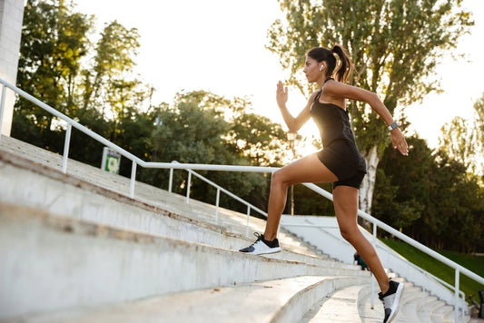 An athlete running quickly up outdoor stairs during a short cardio workout
