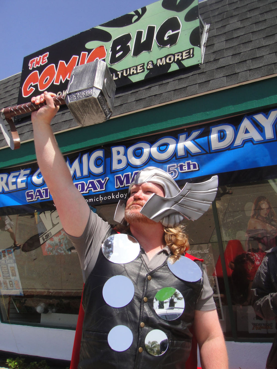 Thor cosplayer raising a replica Mjolnir hammer, representing forearm and grip training