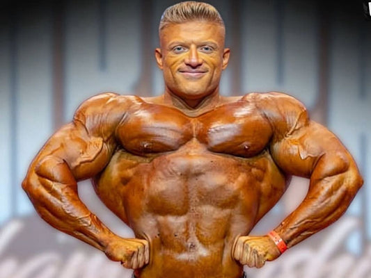 Urs Kalecinski posing on the professional bodybuilding stage with a muscular, competition-ready physique