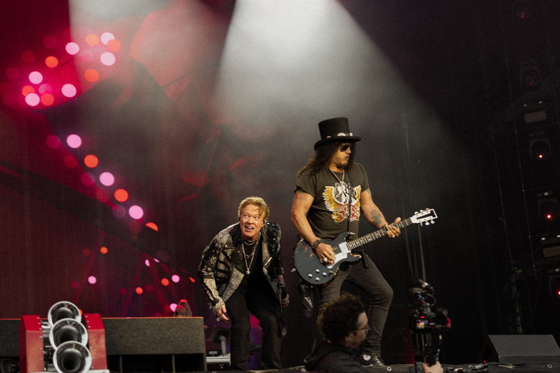 Guns N' Roses performing live with Axl Rose and Slash under blue stage lighting