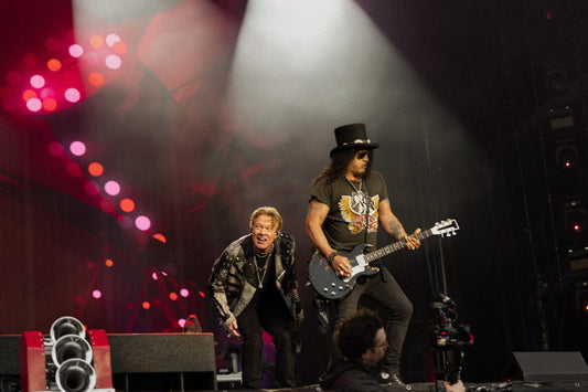 Guns N' Roses performing live with Axl Rose and Slash under blue stage lighting