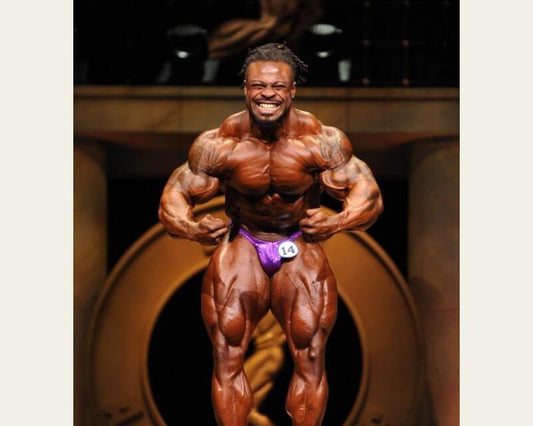 William Bonac performing a most muscular pose at the 2018 Arnold Classic, showing his chest, shoulders, arms and legs