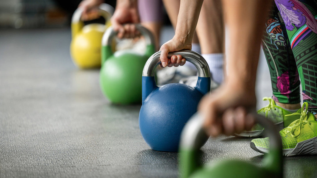 People gripping kettlebells during a group strength-training session