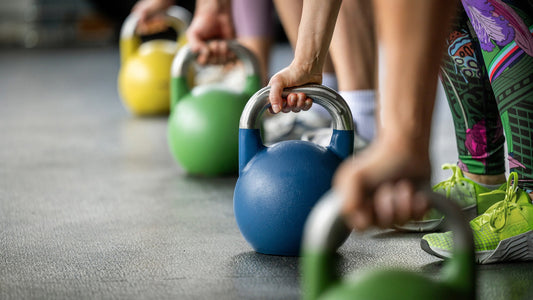 People gripping kettlebells during a group strength-training session