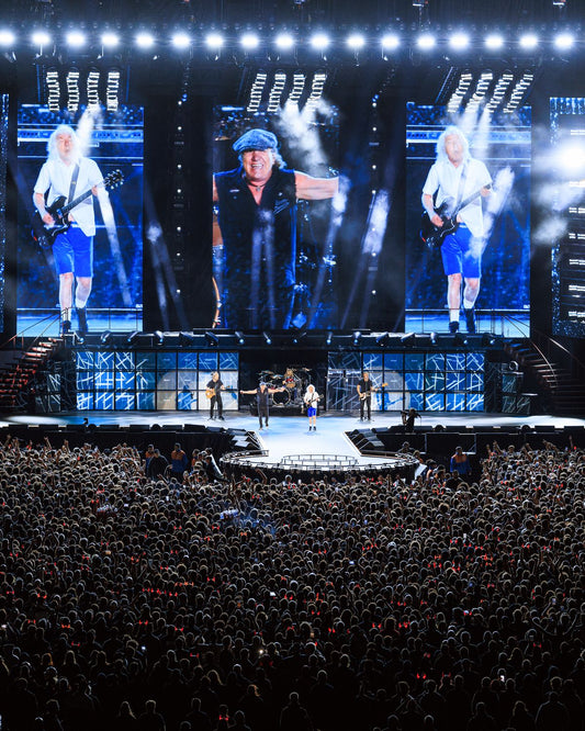 AC/DC playing live on a stadium stage in front of a huge crowd during the Power Up tour