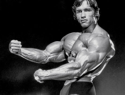 Arnold Schwarzenegger flexing his massive upper arms and triceps in a classic black-and-white bodybuilding pose