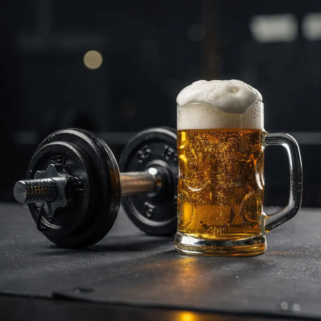 Beer beside a dumbbell, illustrating alcohol and strength training