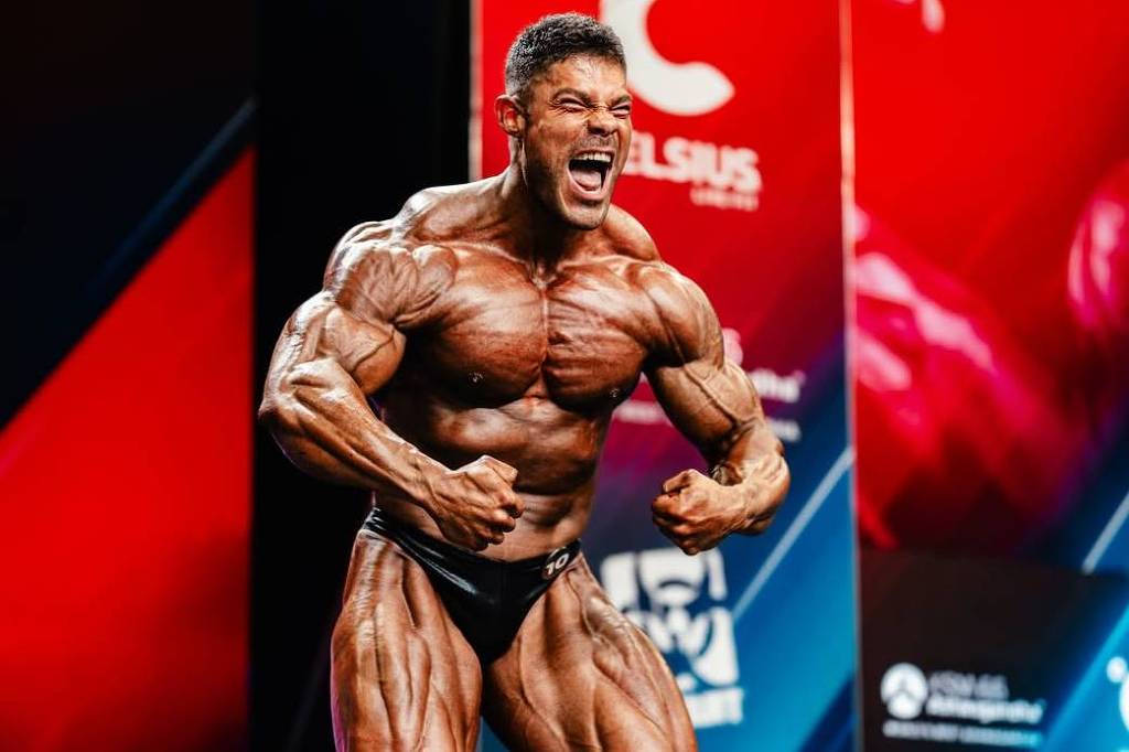 Wesley Vissers posing in black trunks at the 2026 Arnold Classic beside Arnold Schwarzenegger