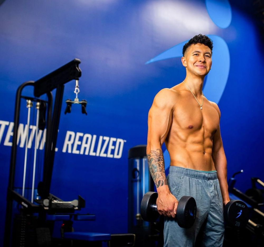 Jeremy Ethier holding dumbbells in a gym
