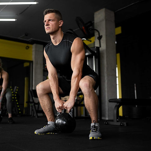 Athlete performing a deep kettlebell squat in a gym