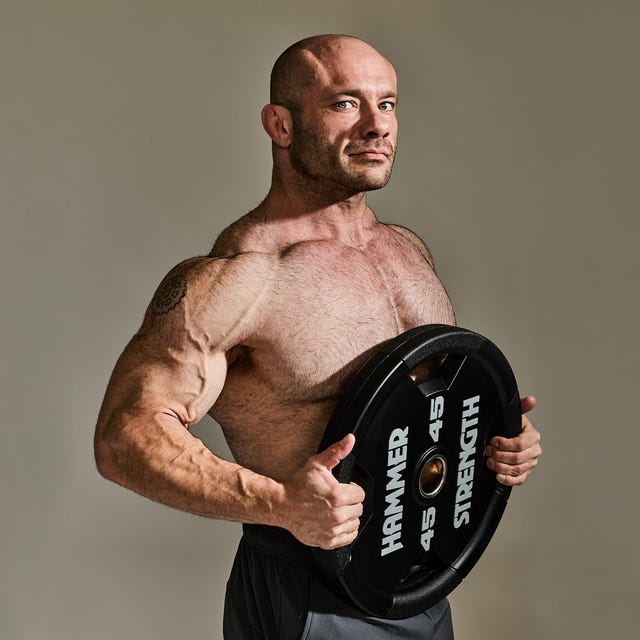 Mike Israetel holding a weight plate in a portrait published alongside his book excerpt