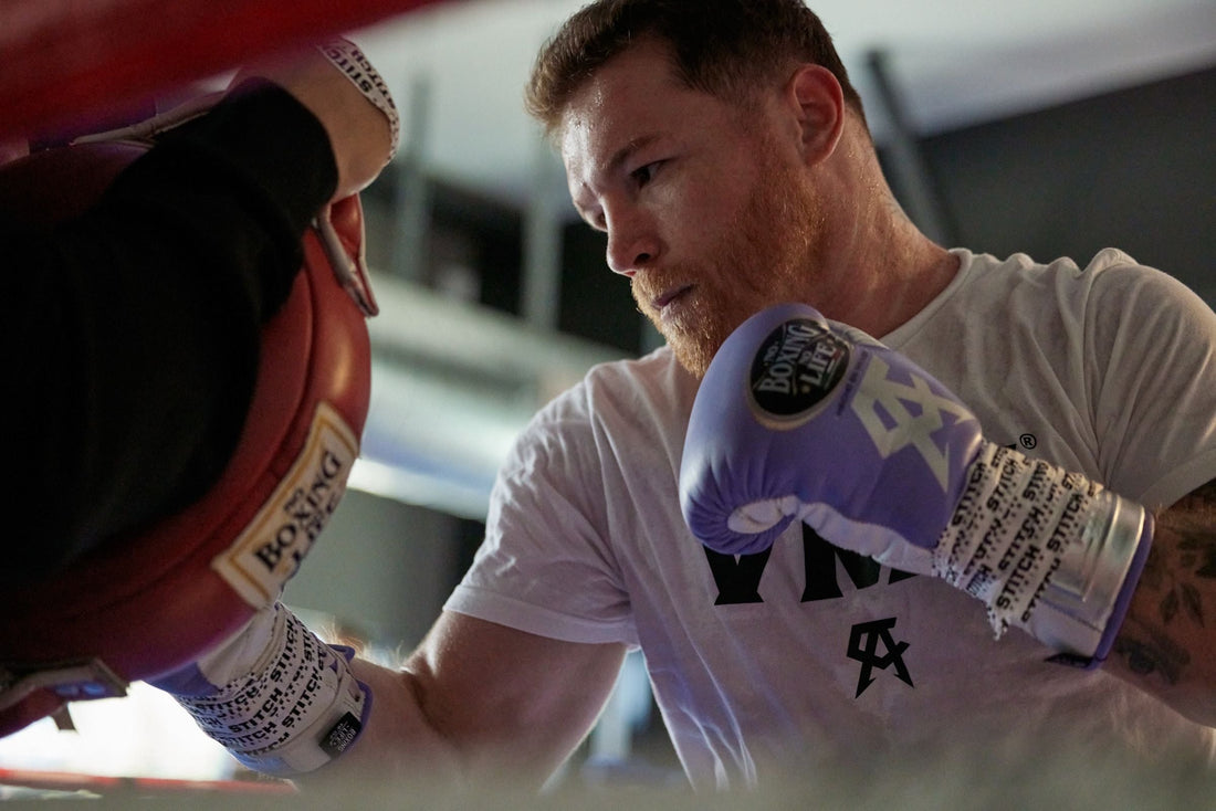 Canelo Alvarez training with focus mitts in a boxing gym; archival training photograph illustrating his 2026 conditioning camp