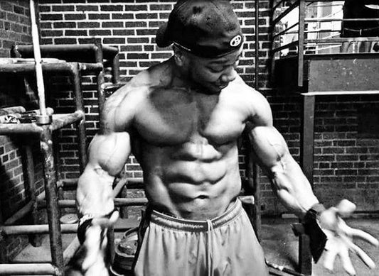 Chris Beastmode Jones posing in a gym, displaying his developed arms and abdominal muscles