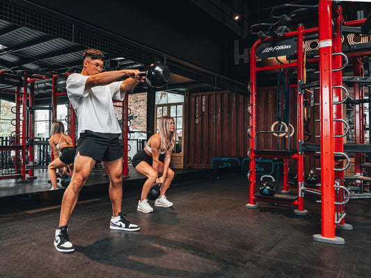 Nicky Holender-inspired functional fitness athlete performing kettlebell training in a gym