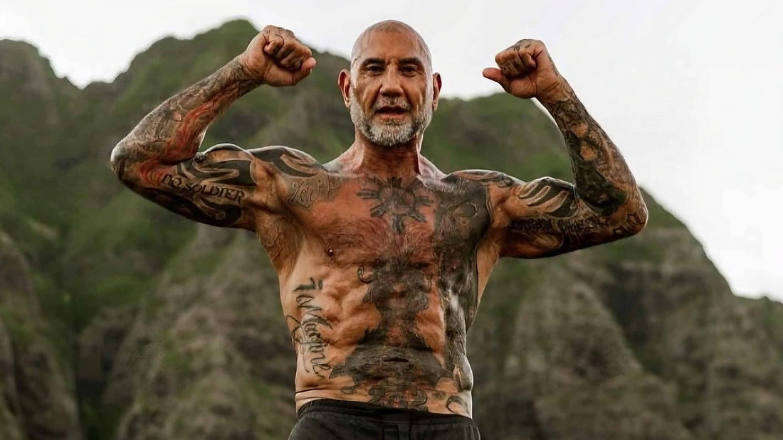 Dave Bautista flexing a muscular Kratos-ready physique outdoors