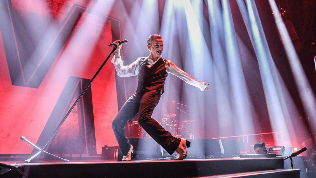 Dave Gahan dancing across a concert stage during a Depeche Mode performance