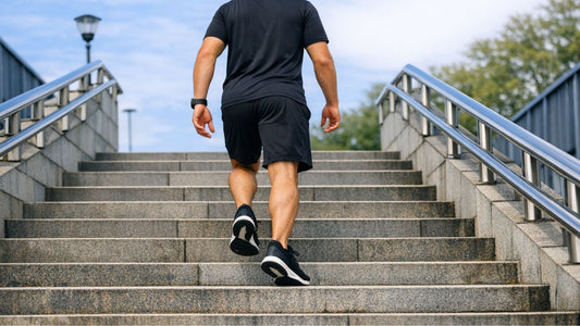 Man in black athletic clothes walking up a broad outdoor staircase