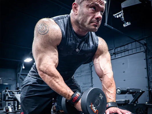 Mike Israetel speaking about fitness science and training in a gym