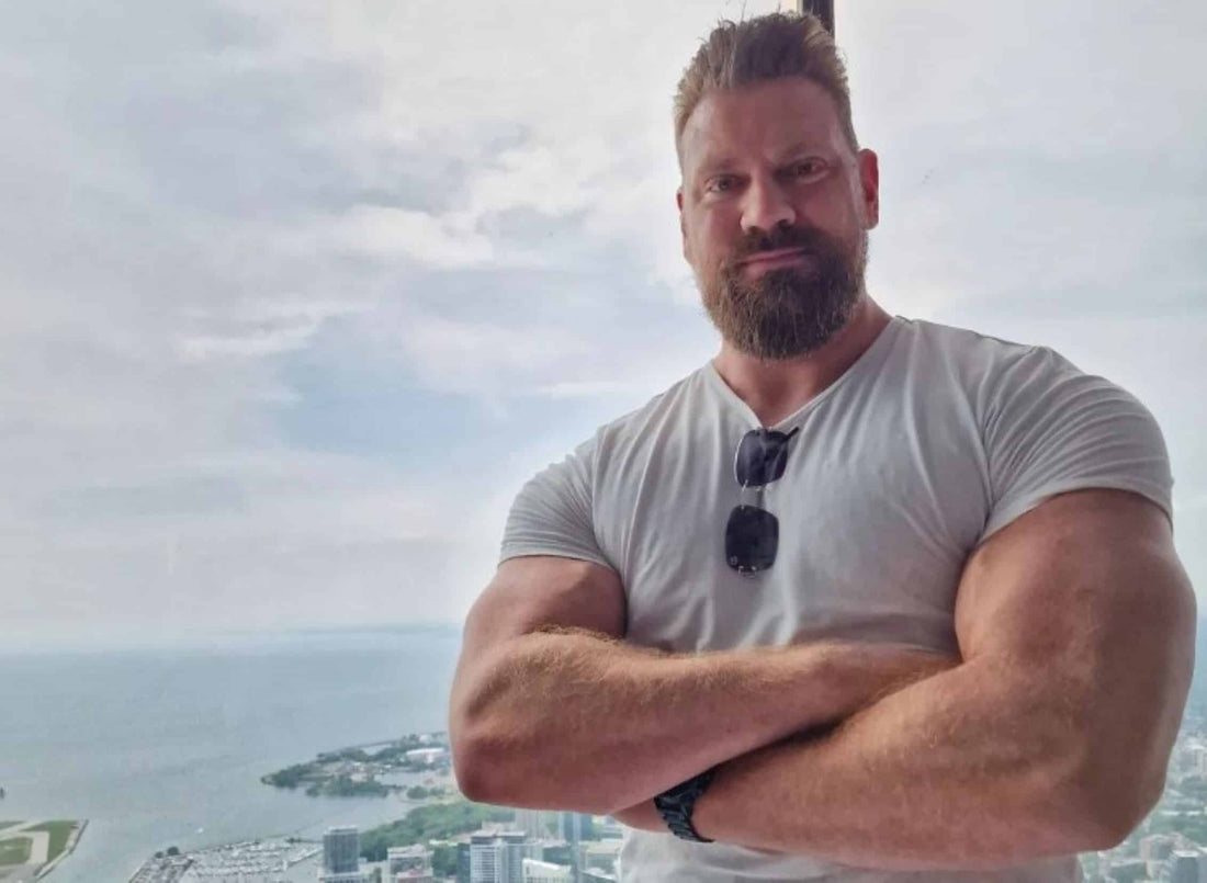 Olivier Richters, the Dutch Giant, standing with muscular arms folded above a coastal city