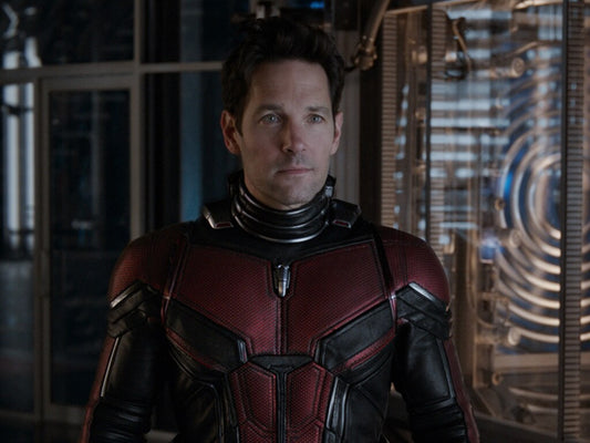 Scott Lang wearing the red-and-black Ant-Man suit in a high-tech laboratory