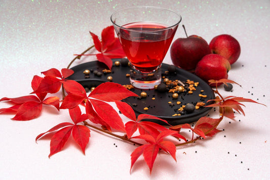 Red apples and a glass of apple juice arranged together in an autumn still life