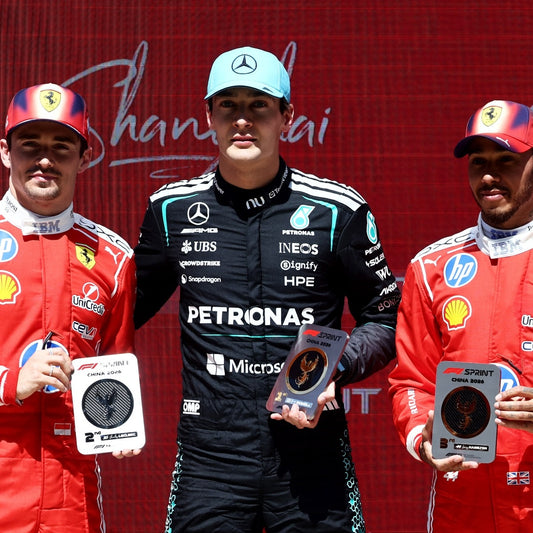 George Russell on the 2026 Chinese Grand Prix Sprint podium with Charles Leclerc and Lewis Hamilton