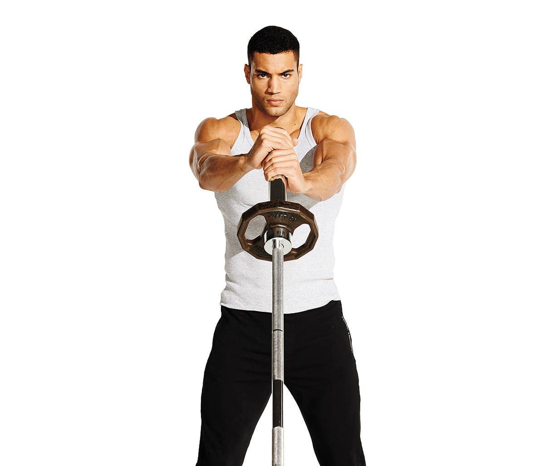 Female athlete in blue sportswear performing a standing landmine barbell rotation in a gym