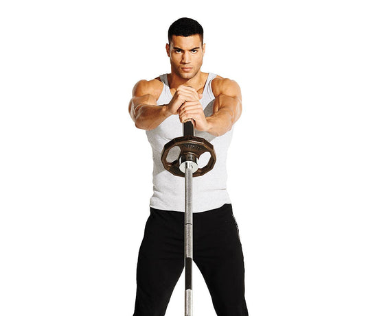 Female athlete in blue sportswear performing a standing landmine barbell rotation in a gym