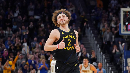 Brandin Podziemski smiles in a black Golden State Warriors jersey during a 2025-26 game
