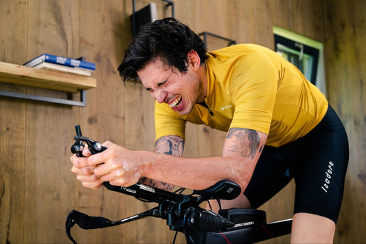 Cyclist pushing through a hard indoor cycling climb