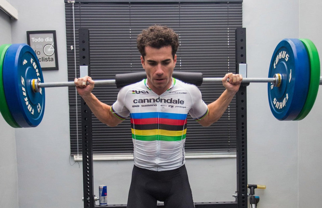 Professional cyclist Henrique Avancini training with a loaded barbell in a squat rack