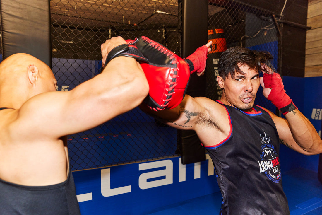 Lewis Tan striking a training pad during a martial-arts gym workout