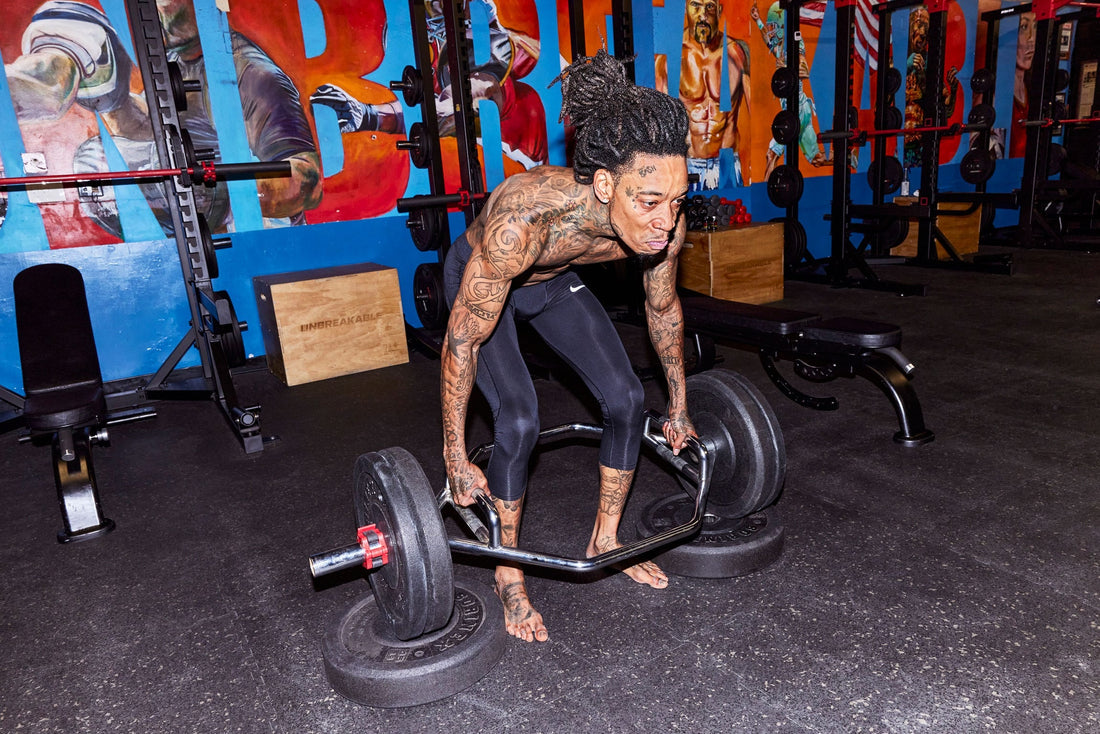Wiz Khalifa preparing a trap-bar deadlift in the gym