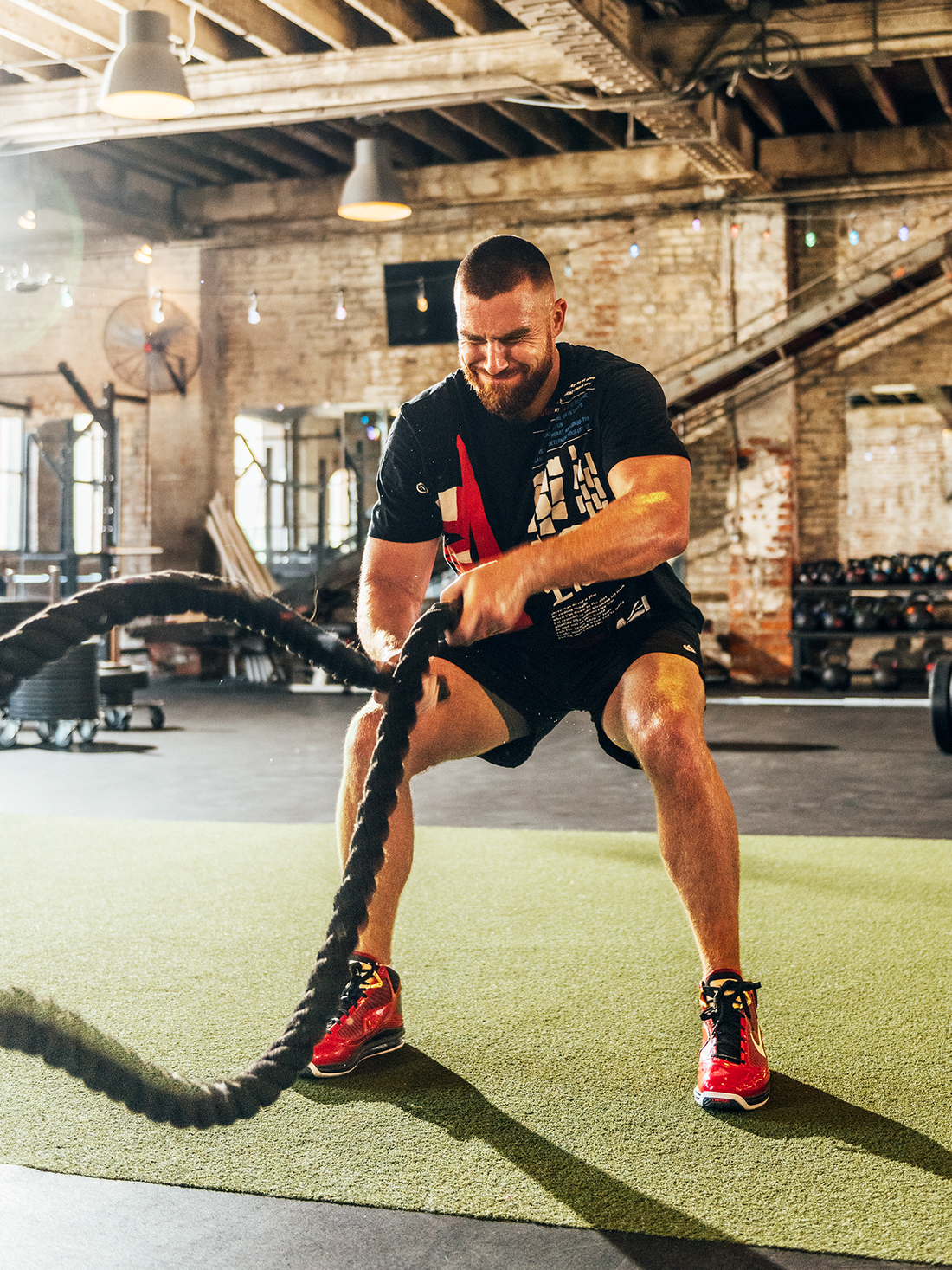Travis Kelce drives battle ropes in a Kansas City training gym