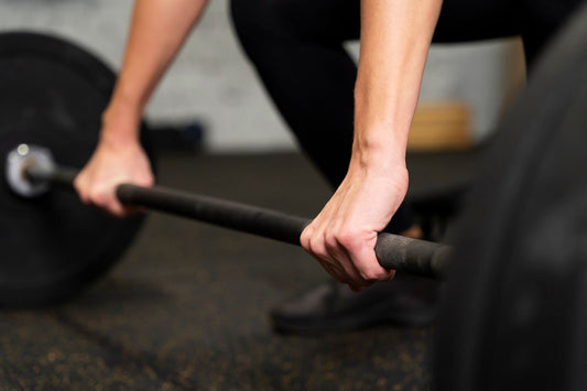 Close-up of a lifter gripping a dumbbell with a visibly working forearm