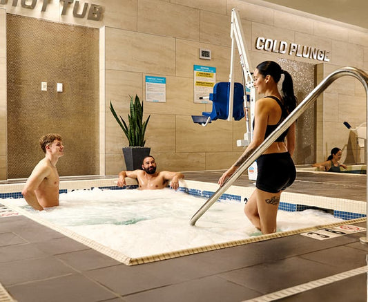 Fitness club recovery area with hot tub and cold plunge facilities illustrating ice baths versus heat after training.