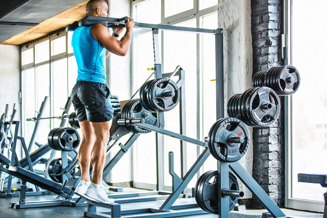 A lifter performing standing weighted calf raises on a machine in a gym