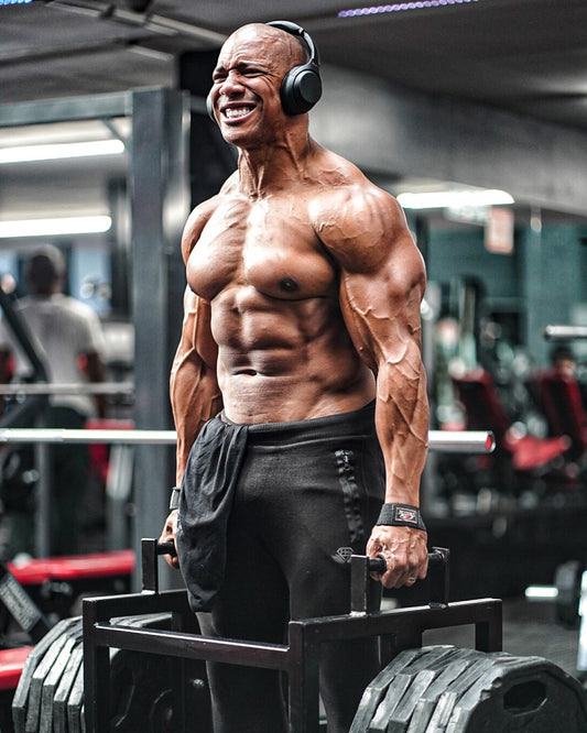 Muscular lifter training with over-ear headphones in a gym