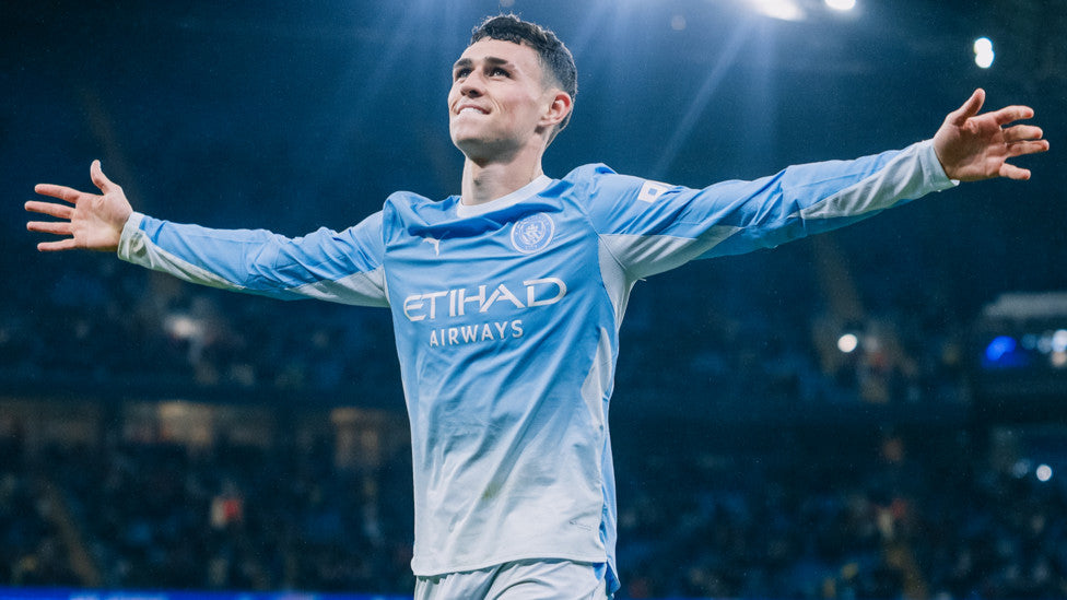 Phil Foden in Manchester City's 2026 sky-blue kit celebrating his hat-trick against AEK Athens